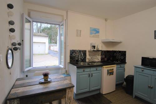 利布尔讷Studio cosy au calme的厨房配有蓝色橱柜和木桌