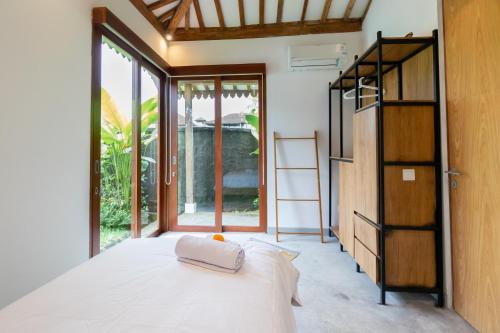 乌布Singgah di Ubud 2的一间卧室设有一张床和一个大窗户