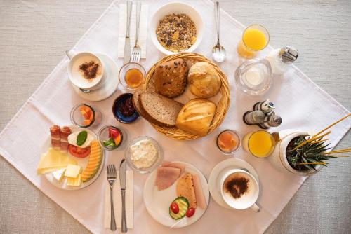 布赖斯高地区施陶芬Gästehaus Kaltenbach的一张带一束早餐食品和饮料的白色桌子