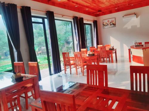 宁平Trang an green river homestay的用餐室设有木桌、椅子和窗户。