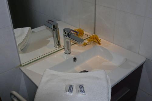 孔佩尔Gîte et chambre d'hôtes Chez Marie的浴室水槽配有白色毛巾和水龙头