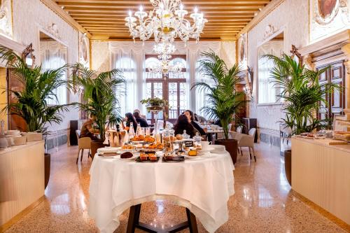 威尼斯Palazzo Keller的用餐室配有餐桌和食物