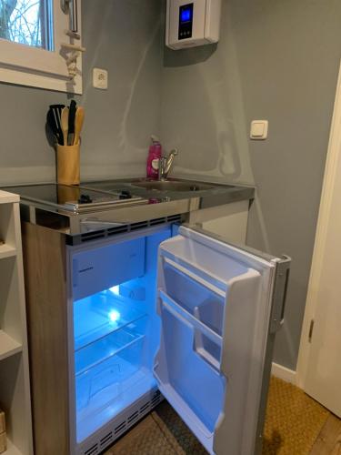 德累斯顿Tiny-Ferienwohnungen Hellerau的厨房配有带蓝色抽屉的开放式冰箱