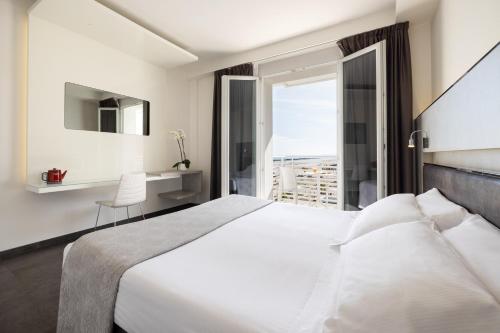 里米尼巴尔迪尼尼酒店的卧室设有一张白色大床和一扇窗户。