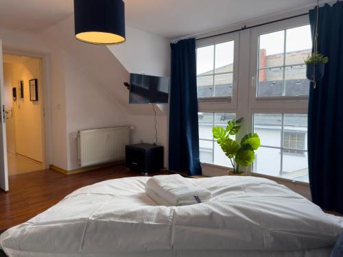 科布伦茨Design Wohnung nähe Uni的卧室设有白色的床和大窗户