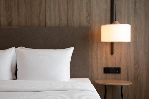 柏林AC Hotel by Marriott Berlin Humboldthain Park的卧室配有白色的床和灯