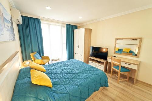 布尔加斯Burgas Beach Resort Apartments的一间卧室配有一张床、一张书桌和一台电视