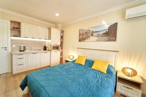 布尔加斯Burgas Beach Resort Apartments的一间卧室配有蓝色的床和黄色枕头