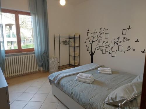 萨尔泰阿诺dimorafelice.sarteano的卧室配有一张床铺,墙上挂着一棵树