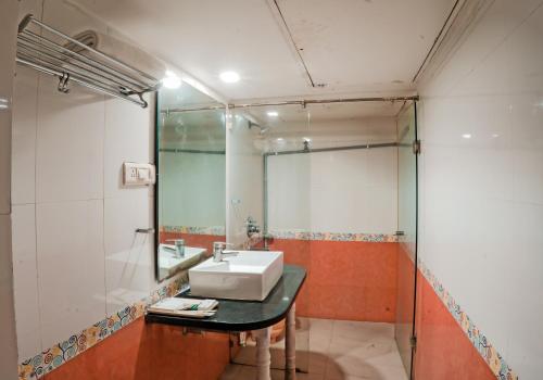博帕尔Pleasure Inn的一间带水槽和镜子的浴室