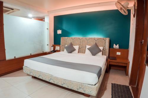 博帕尔Pleasure Inn的一间卧室设有一张蓝色墙壁的大床
