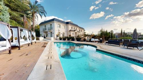 马德里Increíble villa de lujo的房屋前的大型游泳池