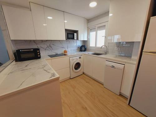 卡拉费尔CalafellBeach.SeaViews,New的厨房配有白色橱柜和洗衣机。