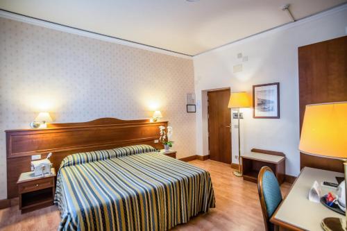 佛罗伦萨马尔泰利酒店的配有一张床和一张书桌的酒店客房