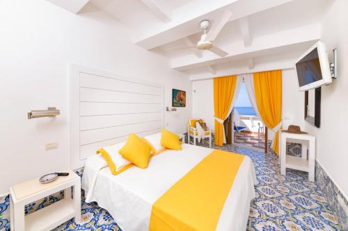 伊斯基亚Hotel Casa Celestino的一间卧室配有一张带黄色枕头的大床