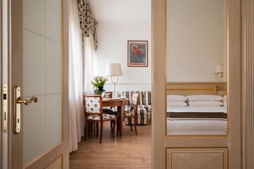 米兰Palazzo Porta Romana Hotel的一间卧室配有一张床、一张桌子和一张书桌