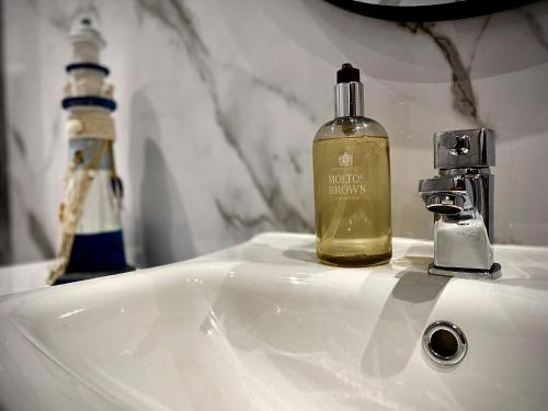 布莱克浦Brand new luxury 3 Bed Hot Tub House in Blackpool的浴室水槽上放一瓶液肥皂