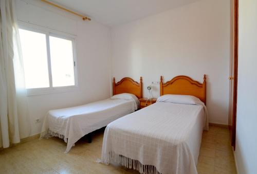 莱斯卡拉Rambla Mallols 29的白色客房的两张床,设有窗户