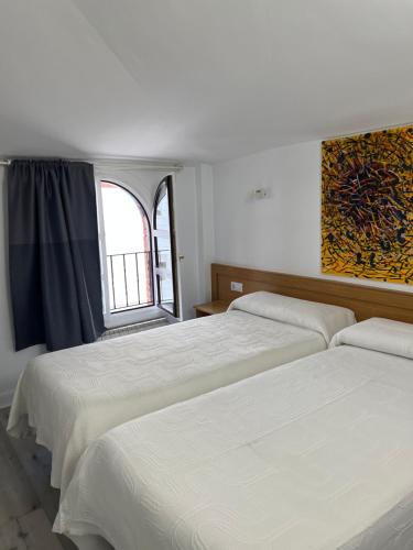 巴拉卡宙斯旅馆的一间卧室设有两张床和窗户。