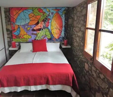 圣巴勃罗-德塞古列斯Hostal La vall的卧室配有红色和白色的床铺和壁画