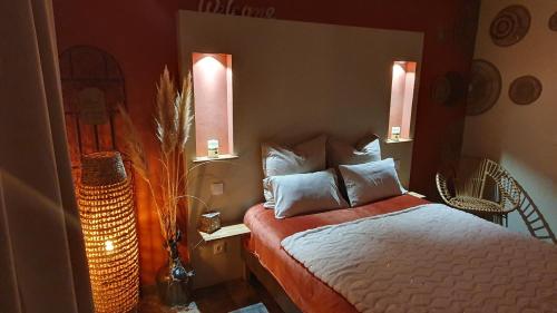 博凯尔Le petit coin de Provence的卧室配有一张床,墙上有两盏灯