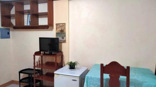 长滩岛CORALYN'S PLACE standard room的小房间配有电视和带电视机的桌子