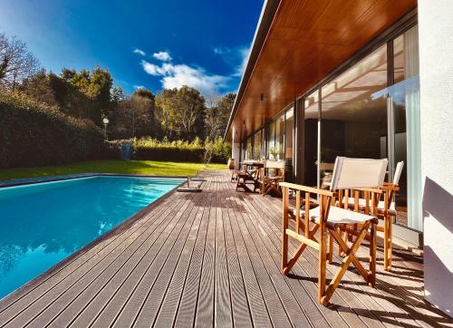 维亚纳堡Casa das Bolotas的游泳池旁带椅子的木甲板