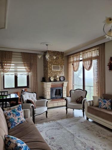AraklıTrabzon Deniz Manzaralı villa的客厅配有沙发、椅子和壁炉