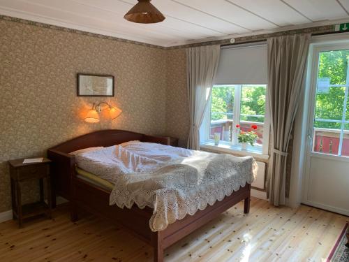 DockstaVilla Skuleskogen的一间卧室配有一张带白色棉被的床和两个窗户