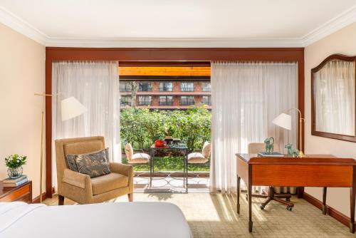 内罗毕费尔蒙诺福克酒店的一间卧室配有一张床、一张桌子和一把椅子