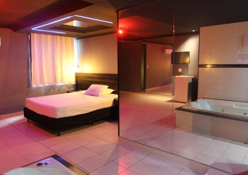 塔瓜汀加Gran Motel的一间卧室配有一张床和浴缸