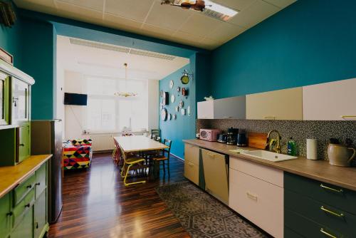 德累斯顿拉拉鲁德累斯顿旅舍的一间带蓝色墙壁的厨房和一间带桌子的用餐室