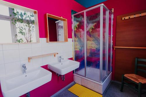 德累斯顿拉拉鲁德累斯顿旅舍的粉红色的浴室设有水槽和淋浴
