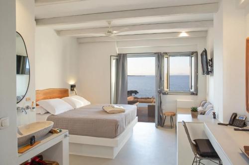 纳乌萨Paros Cape Suites的一间卧室配有床和水槽,还有一间浴室