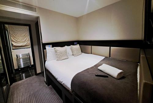 伦敦大圣海伦酒店的卧室配有一张带白色床单和枕头的大床。