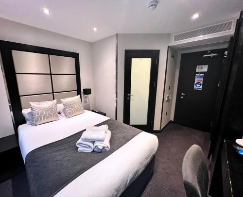 伦敦大圣海伦酒店的酒店客房,配有带毛巾的床