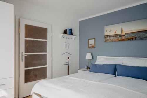 布雷滕布鲁恩Das kleine Haus的卧室配有白色的床和蓝色的墙壁
