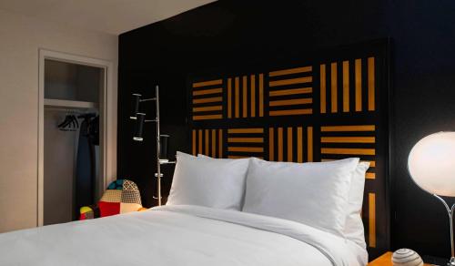 德梅因德梅因萨弗里万丽酒店的一间卧室配有一张白色的床和黑色床头板