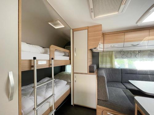 黑灵斯多夫Mietwohnwagen 01的小房间设有两张双层床和一张沙发