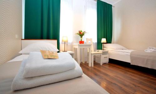 克拉科夫克拉科夫中央公寓酒店 的酒店客房,设有两张床和绿色窗帘