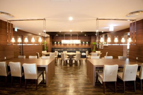 岐阜岐阜伊尔克雷多酒店的用餐室配有桌子和白色椅子