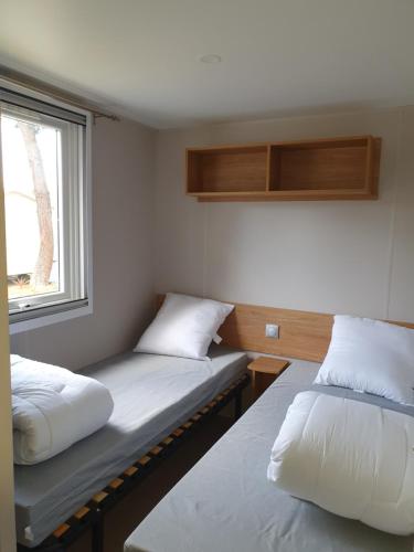 圣让-德蒙Camping du Bois Dormant的小型客房 - 带2张床和窗户