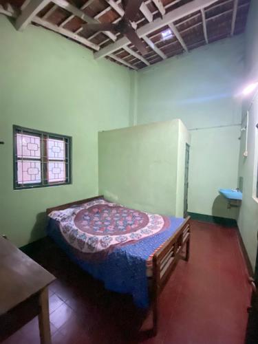 比纳里姆Castellos tourist nest的卧室位于客房的角落,配有一张床