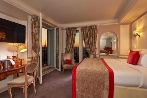 巴黎卢浮宫里贾纳酒店的酒店客房设有一张床、一张书桌和窗户。
