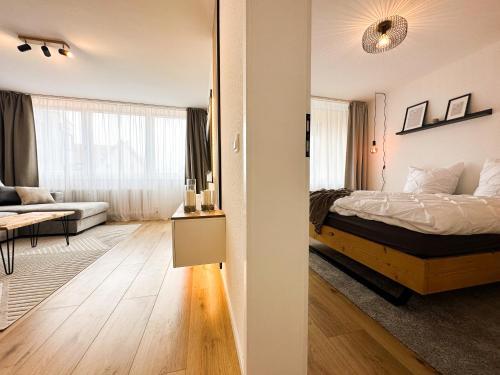 布伦瑞克Kirchturm-Panorama - Apartment mit Balkon im Herzen von Braunschweig的一间卧室设有一张床和一间客厅。