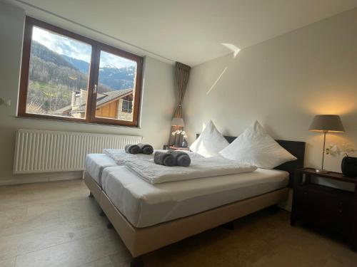 安特特泽Wunderschöne Wohnung am See mit Sauna & Whirlpool的一间卧室设有一张大床和大窗户