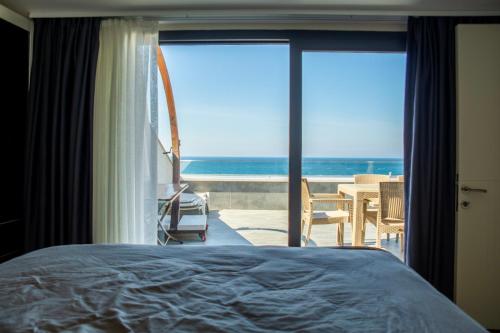 库萨达斯Duplex Loft mit Panorama Seaview的一间卧室配有一张床,享有海景