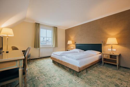费尔德基希Hotel Bären的一间卧室配有一张床、一张书桌和一个窗户。