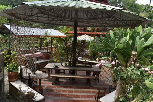 RíoverdeHostal Villa del Rio的一个带野餐桌的伞下庭院