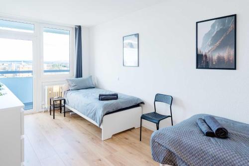 美茵河畔哈瑙Chic City-View Apartments in Hanau的一间卧室配有两张床和椅子